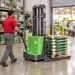 Store associate steering the EKKO EB13C-118Li walkie stacker with a pallet of potting soil in a retail stockroom